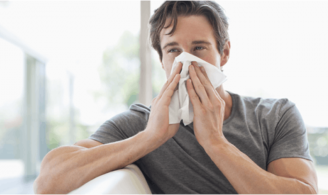 Man blowing nose into a tissue