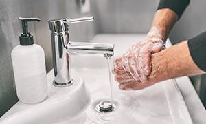 Person washing hands with soap