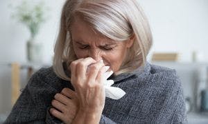 Mature woman suffering from a cold and sneezing