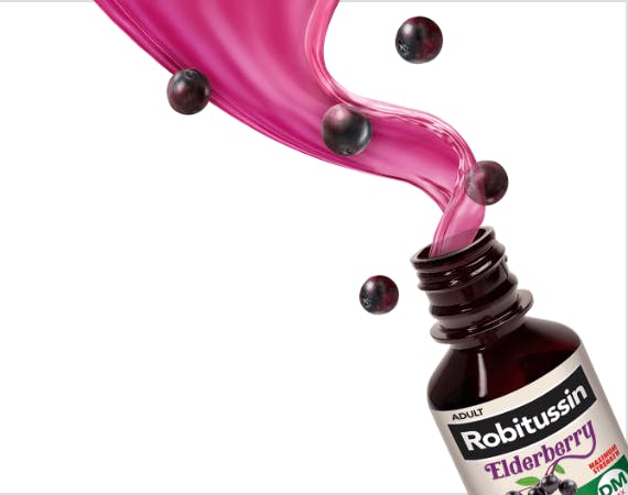 Adult Robitussin Elderberry DM with liquid spilling out surrounded by floating elderberries