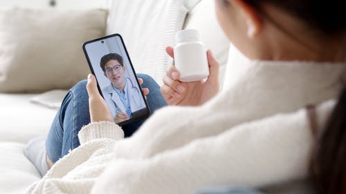 Woman consulting doctor via telehealth