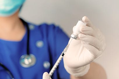 A person is putting the vaccine into a syringe