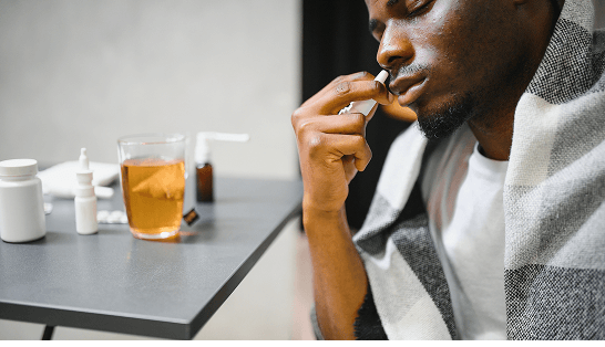 Man with a cold blowing nose into a tissue 