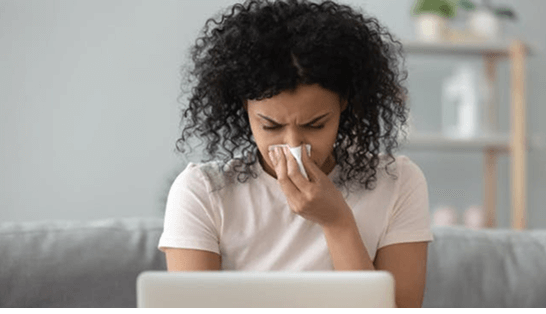 Man with a cold blowing nose into a tissue 