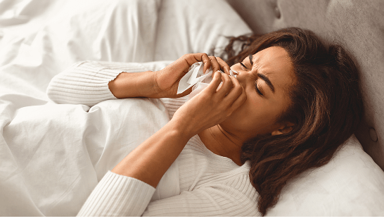 Man with a cold blowing nose into a tissue 