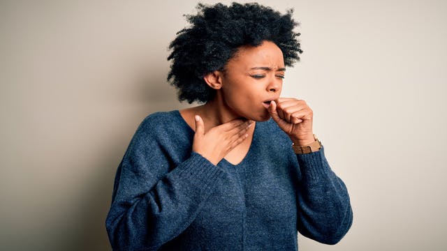 Black woman coughing.
