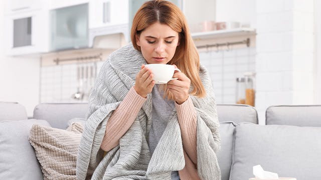 Woman drinking hot beverage at home