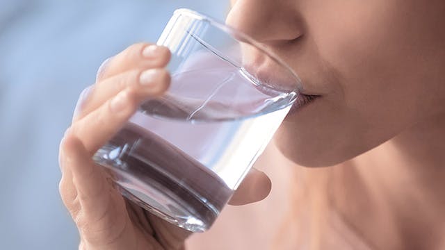 Close up cropped image thirsty woman holding glass drinks still water preventing dehydration