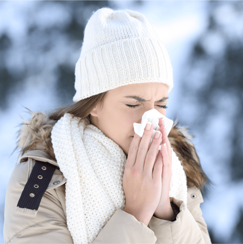 Woman sneezing into tissue