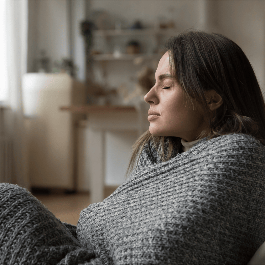 Woman sneezing into tissue