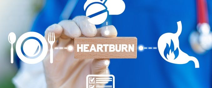 medical professional holding block that reads ‘heartburn