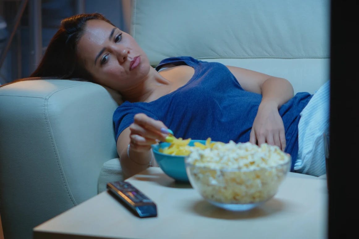 Woman lying down eating a late night snack