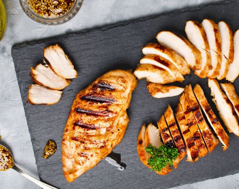 sliced grilled chicken on a cutting board