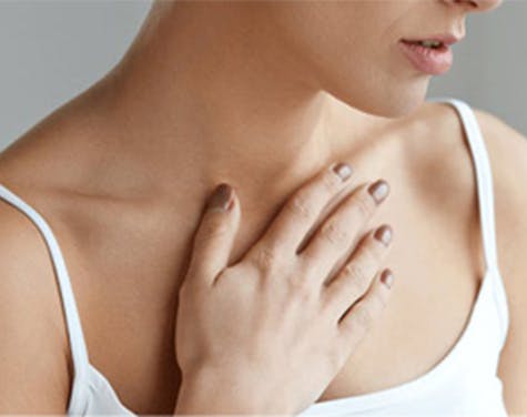 Woman with heartburn, hand on her chest