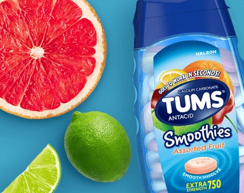 Image of a bottle of TUMS Smoothies Product along with cut oranges and limes