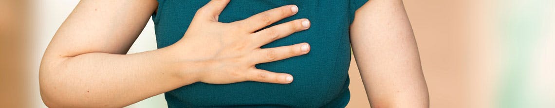 Pregnant woman holding chest