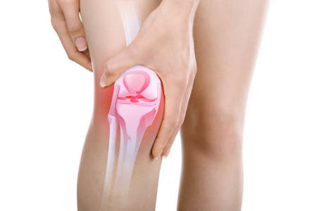 膝の痛みを抑える女性 