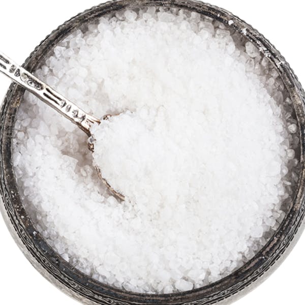 A bowl of iodised salt with a serving spoon. 