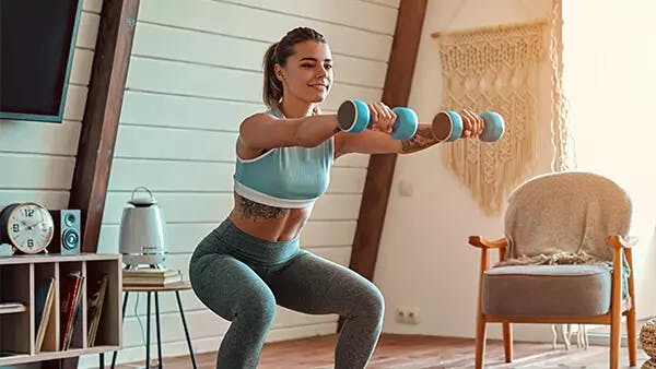 Woman doing squat exercises with weights