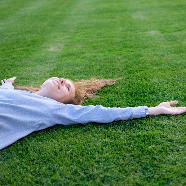 Woman relaxing in a field of grass. 