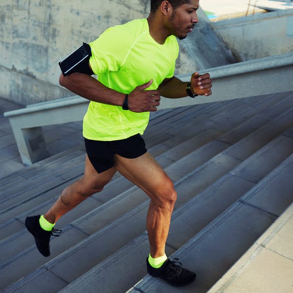 Athletic man running up stairs.