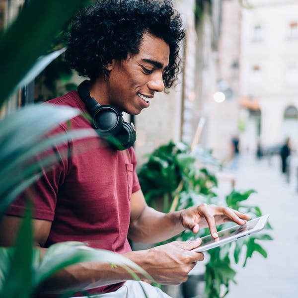 Man wearing headphones using a digital tablet.