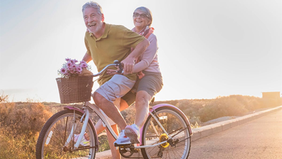 A happy couple riding a bike together