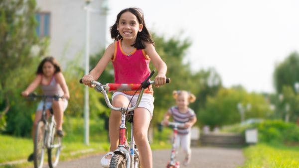Three children riding bicycles