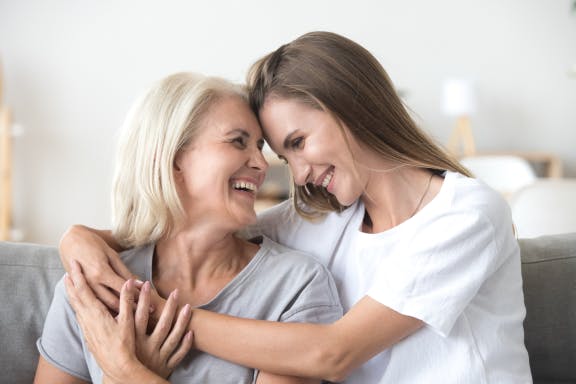 Daughter smiling and hugging her mother