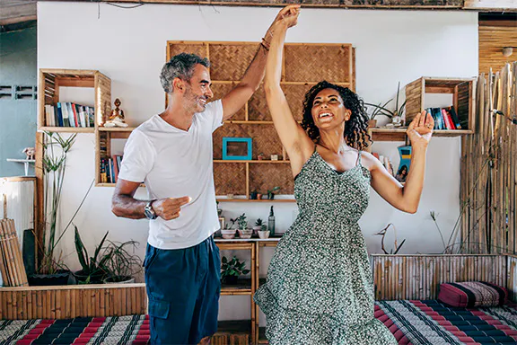 A happy couple dancing in the room