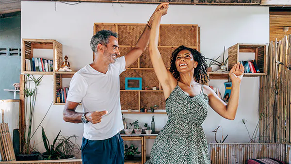 A happy couple dancing in the room