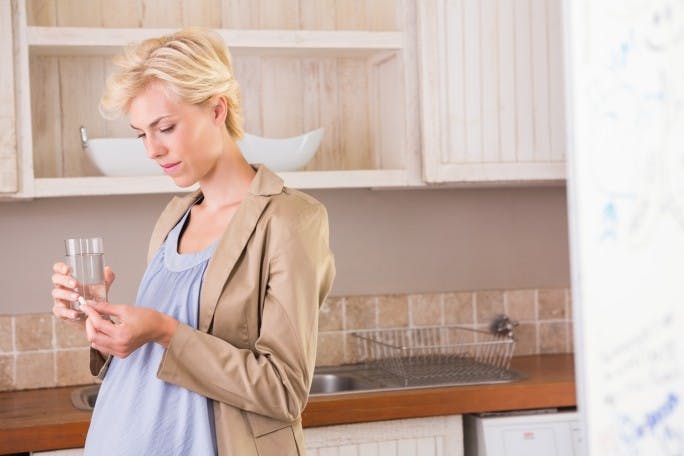 Pregnant woman taking a vitamin