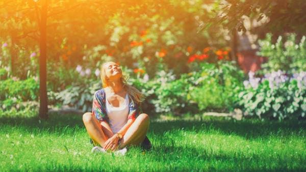 Happy woman sitting outdoors looking carefree