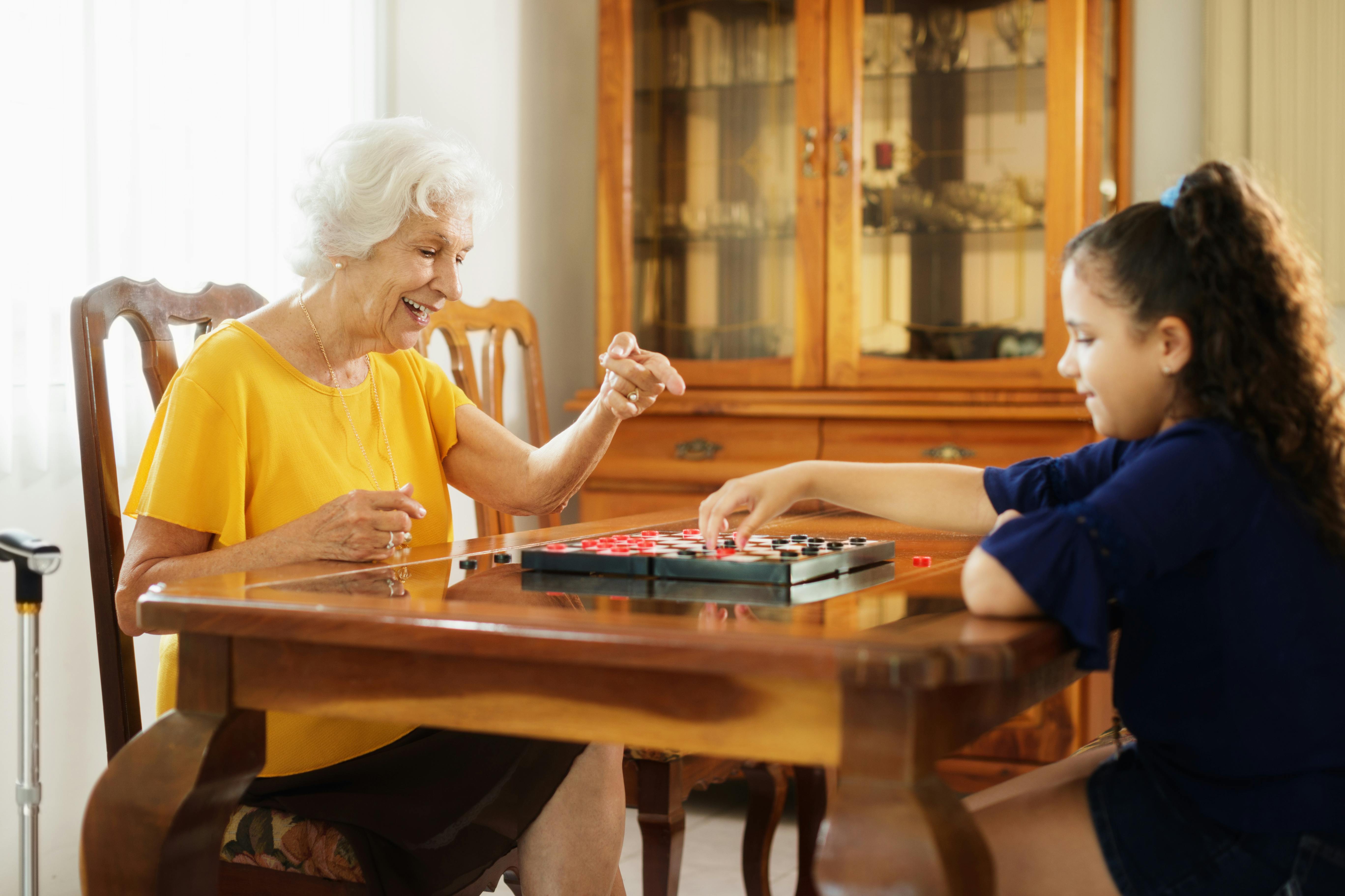 Grandmother and granddaughter playing checkers