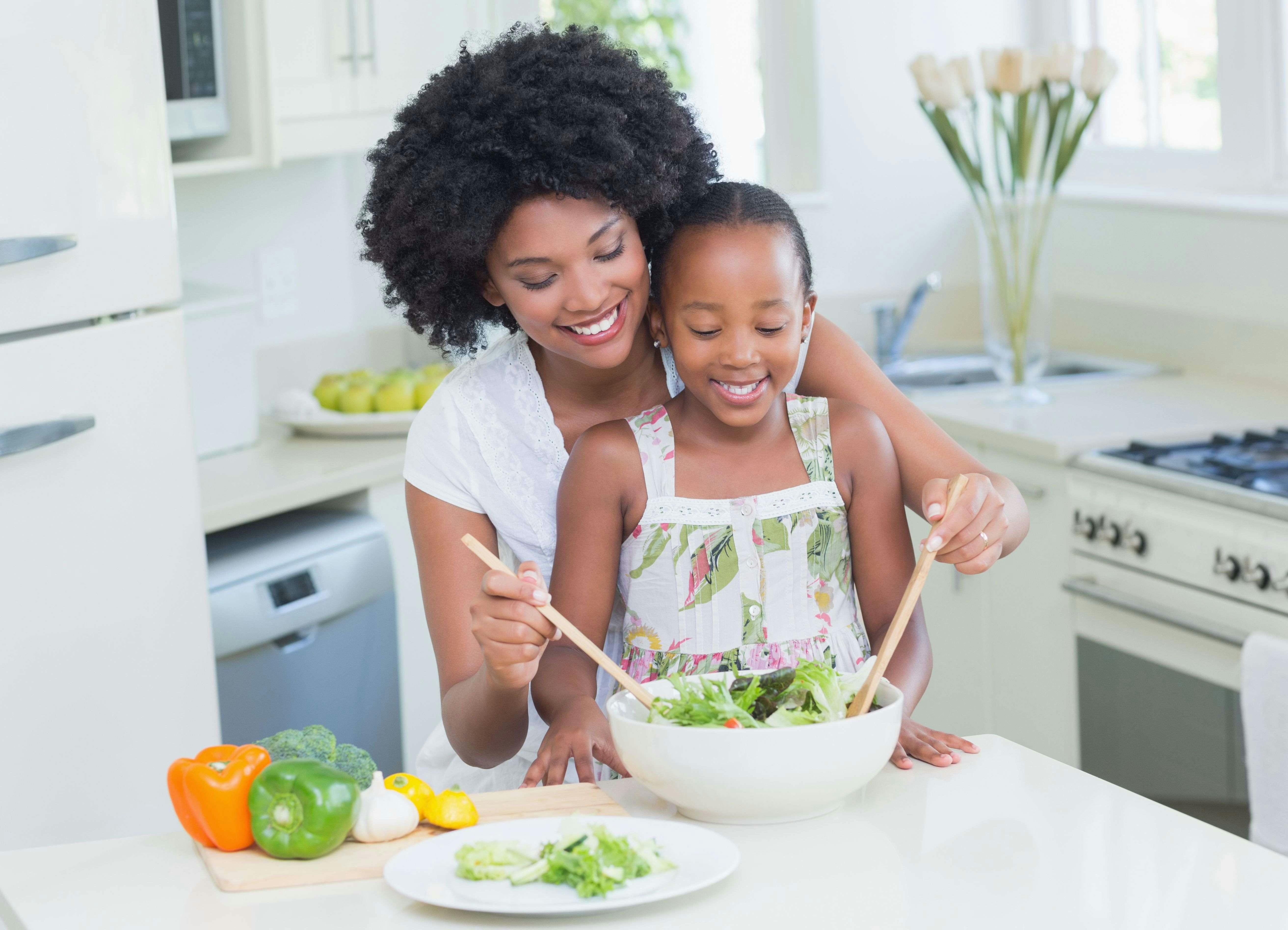 Mother and daughter making salad together in the kitchen