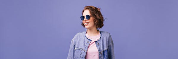 young woman leaning on bike and smiling