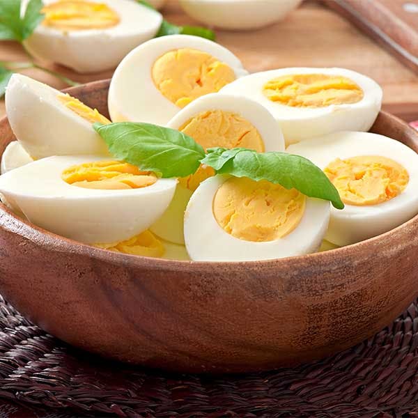 hard boiled eggs in a bowl with parsley on top