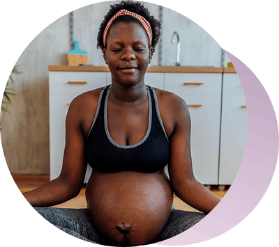 Pregnant woman sits in yoga pose