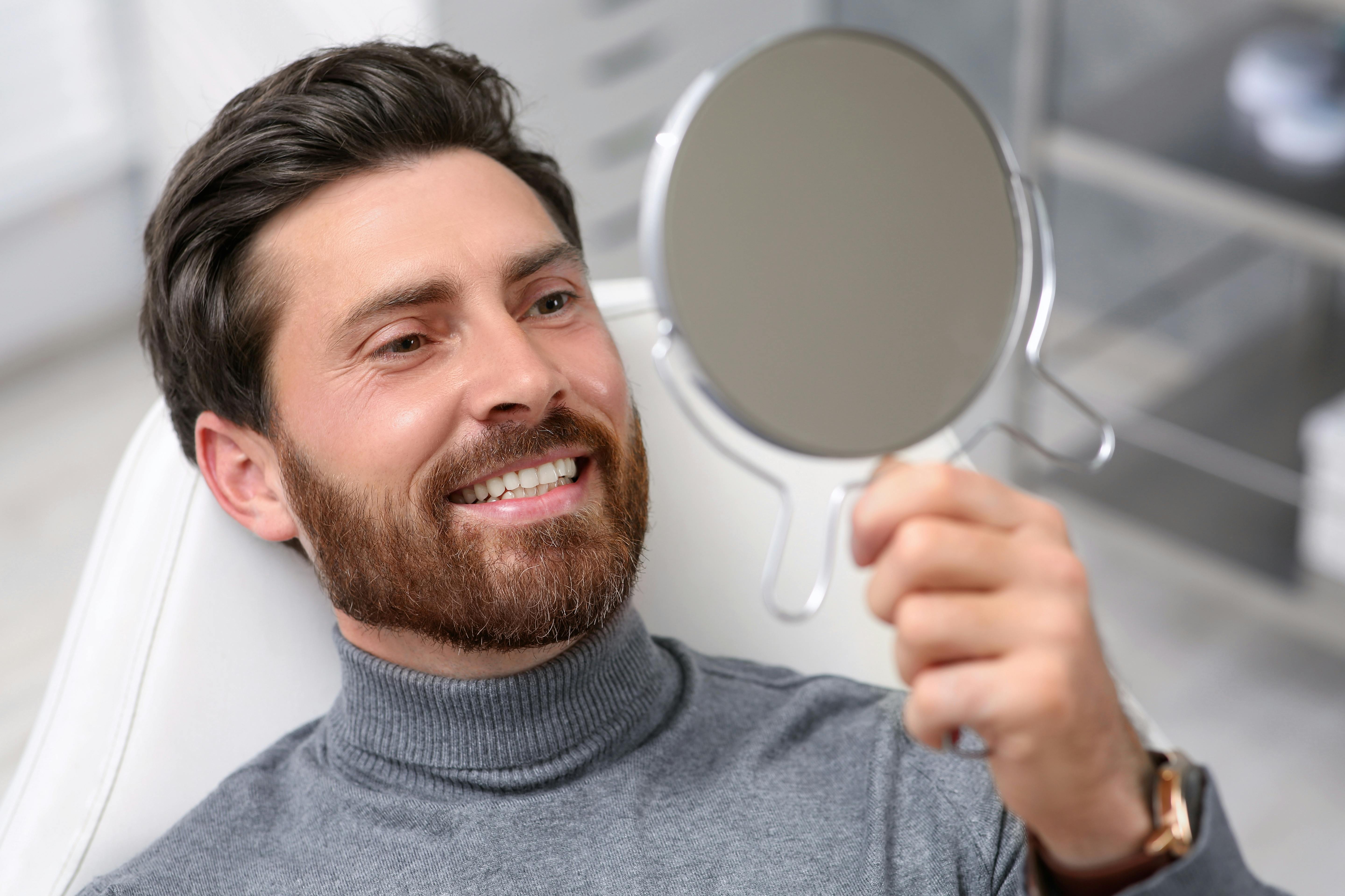 A person looking at their teeth in a mirror