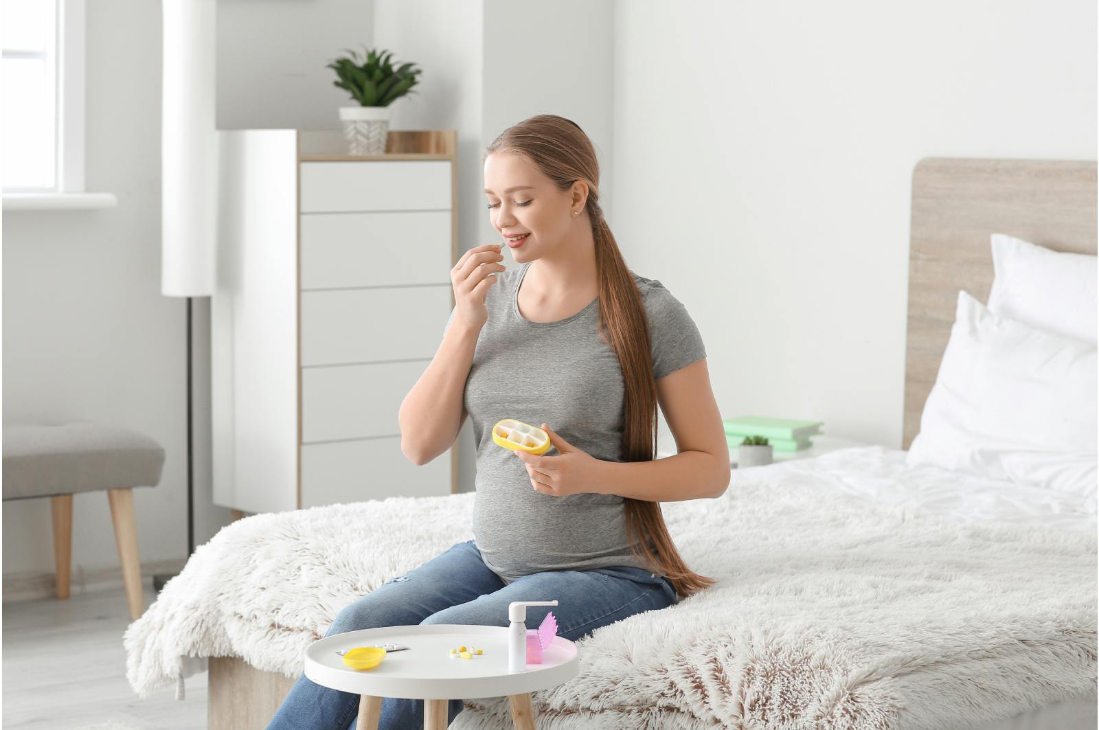 Pregnant woman taking vitamins at home