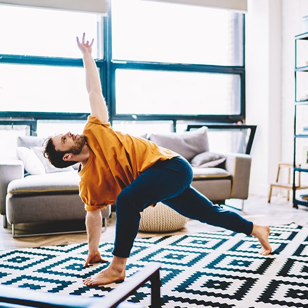 Person doing yoga stretches in their living room 