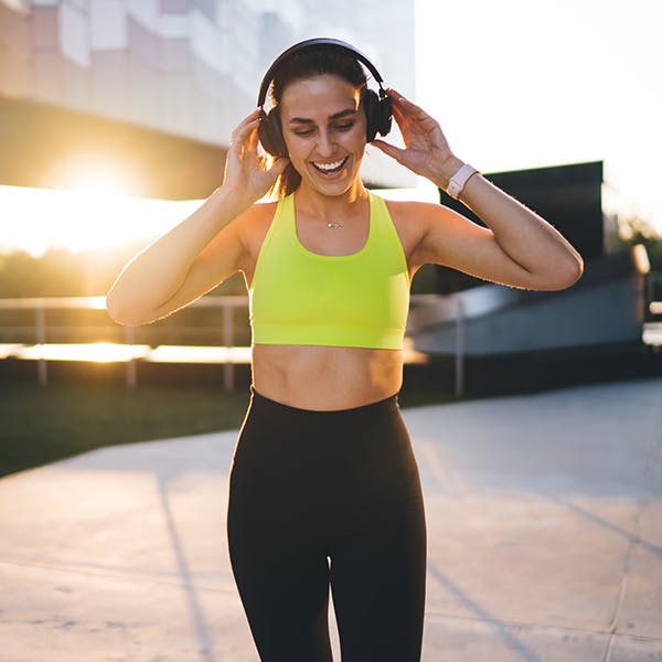 Woman listening to her headphones in workout clothes Woman listening to her headphones in workout clothes