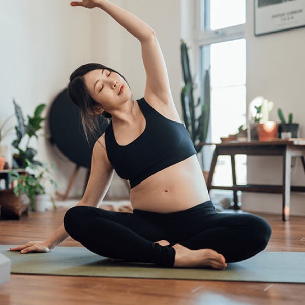 Pregnant women stretches in yoga class
