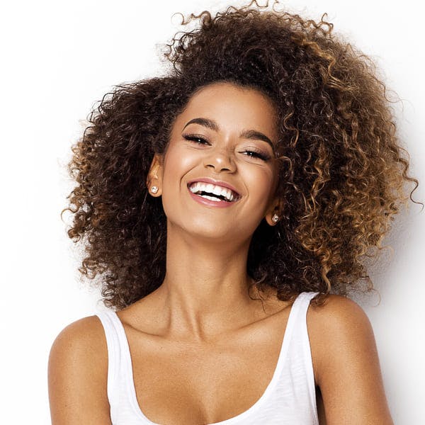 Happy beautiful woman smiling against blank background