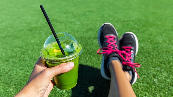 woman drinking green smoothing