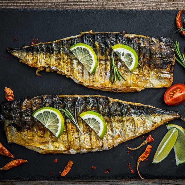 dos pescados cocinados con un limón encima