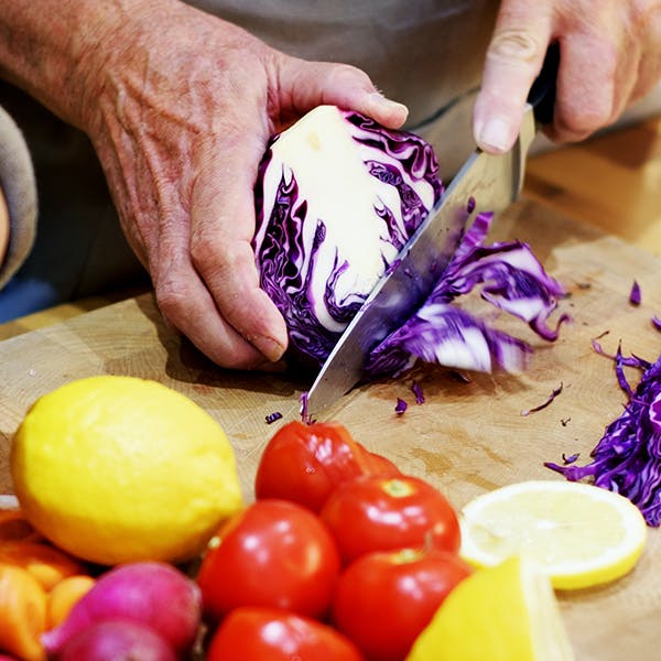 hombre cortando vegetales en una tabla para picar