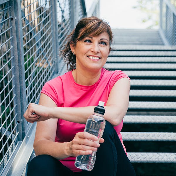 Smiling woman sitting on a stairway outside