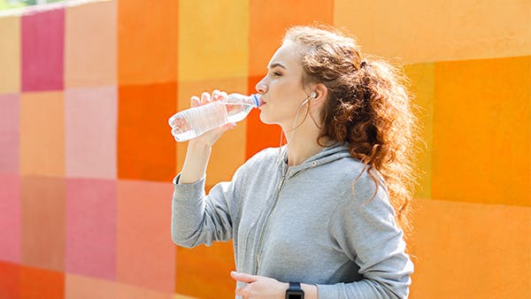 Mujer joven bebiendo una botella de agua