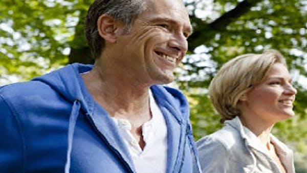middle aged couple in sweatshirts smiling while outdoors